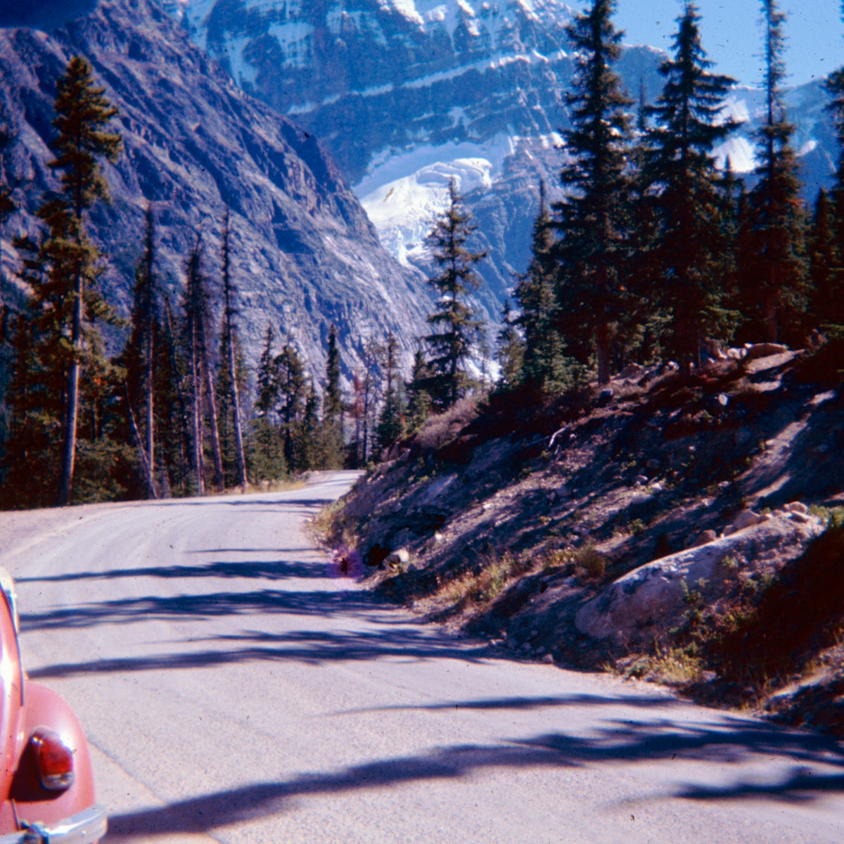 Red car driving on a scenic mountain road